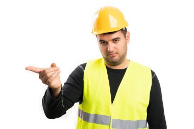 Ciddi ifadeleri olan, sarı kasklı ve floresan yelekli bir erkek müteahhit ya da beyaz stüdyo arka planında işaret parmağı olan dikkatli bir jest.