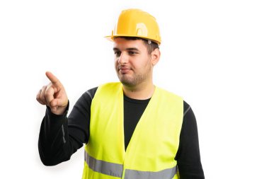 Sarı kasklı ve floresan yelekli yetişkin bir adam görünmeyen ekranda reklam için boş telif alanına dokunuyor ve işaret parmağı beyaz arka planda izole ediliyor.