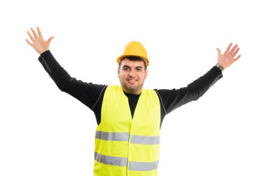 Çalışan yelek ve güvenlik kaskı takan neşeli yetişkin müteahhit elleri beyaz arka planda izole bir şekilde kutlama jesti yapıyor.