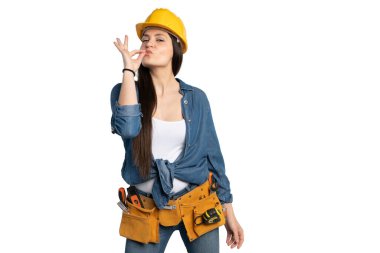 Sarı bir şapka ve alet kemeri takan kendine güvenen bir kadın inşaat işçisi, mükemmellik ve memnuniyeti simgeleyen şakacı bir 