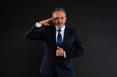 Ciddi bir ifadeyle selamlama, saygı ya da disiplin gösterme, siyah arka planda izole edilmiş, kendine güvenen olgun iş adamı..