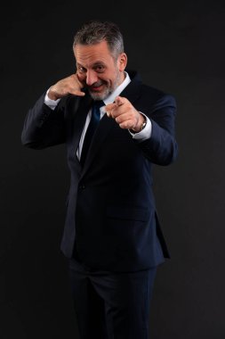 Kendinden emin iş adamı gülümsüyor, kameraya bakıyor ve bana jest diyor, iletişimi ve nişanı simgeliyor..