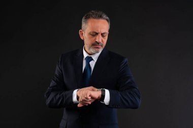 Kol saatine bakan takım elbiseli olgun bir işadamı zaman yönetimini, dakikliği ya da aciliyeti simgeliyor..