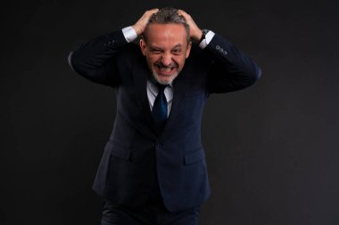Hüsrana uğramış takım elbiseli işadamı dişlerini sıkıyor ve iki eliyle birden öfke ve stres içinde başını tutuyor. Krizin, tükenmenin ya da büyük bir mesleki gerilemenin sembolü.