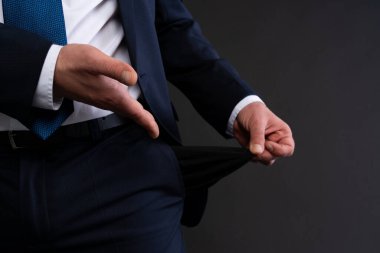 Donanma takım elbiseli ve mavi kravatlı bir işadamının mali sıkıntı ve iflasın sembolü olarak boş bir cep çıkarması..