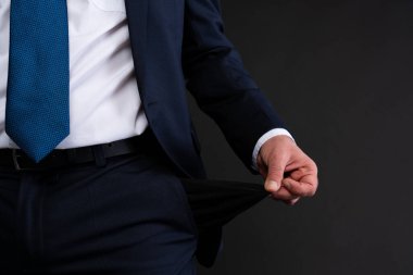 Resmi giyinmiş bir işadamının cebini boşaltması, parasızlık ya da maddi sıkıntıları simgeliyor..