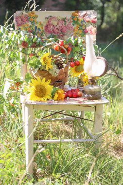 Kırsal konsept, eski bir klasik sandalye, bir sürü kır çiçeği ve güzel bir yaz bahçesinde çekilmiş bir buket ayçiçeği.