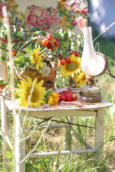 Kırsal konsept, eski bir klasik sandalye, bir sürü kır çiçeği ve güzel bir yaz bahçesinde çekilmiş bir buket ayçiçeği.