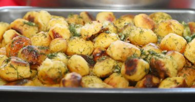 Bir avuç vişneli domatesle dekore edilmiş lezzetli ev yapımı patates kroketlerinin yakın plan fotoğrafı.