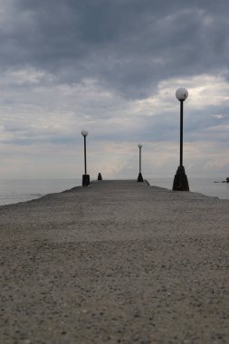Yunanistan 'ın Paralia kentinin rıhtımında sokak lambalarıyla çevrili deniz manzarası