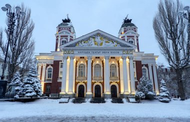 Calm winter evening in the city of Sofia with the beautiful building of the National Theatre of Bulgaria which conveys an aristocratic look to the picture with its neo-baroque style clipart