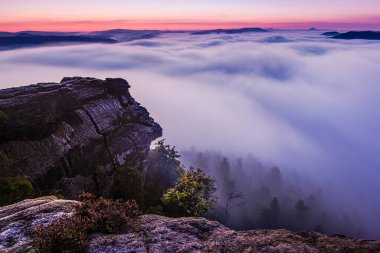 Renkli bir gündoğumu sırasında nehrin üzerindeki kayalardan muhteşem bir manzara. Nehirden gelen soğuk harika bir sis yaratıyor..