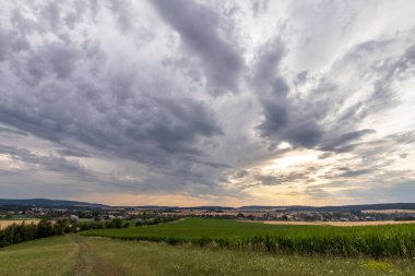 Dramatik gökyüzü ve renkli batan güneşle akşam manzarası.