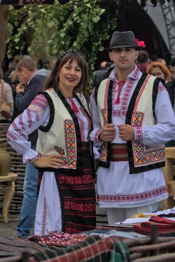 Chisinau, Moldova - October 2, 2022: National Wine Day celebration in the capital. Young man and woman in national costumes at the Wine Day event. Mass celebrations.