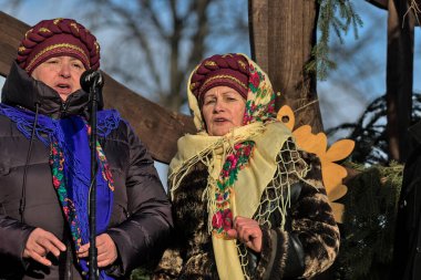 Kyiv, Ukrayna - 7 Ocak 2022: Ortodoks Noel kutlamaları sırasında Ukraynalılar ulusal kostüm giydiler. Noel tatili boyunca geleneksel Noel şarkıları. Eski kış gelenekleri.