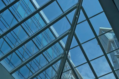 Çeşitli geometrik şekillerin soyut fotoğrafı. Mavi gökyüzü, cam ve metal yapılar. Basit kentsel mimari arka plan.