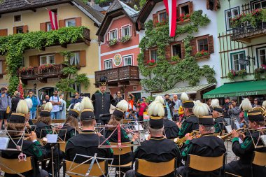 Hallstatt, Austria - July 1, 2023: Concert of the national orchestra on the main square. The musicians are dressed in festive colorful costumes. Famous old town of Hallstatt, Upper Austria. clipart