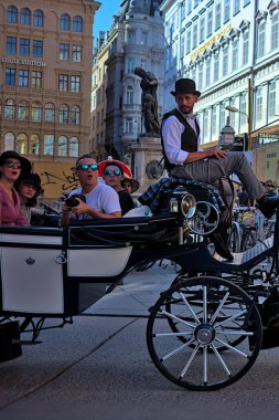 Viyana, Avusturya - 29 Haziran 2023: Viyana 'nın tarihi merkezini gezen bir grup mutlu, ağzı açık turist. Eski şehrin sokakları ve mimarisi.