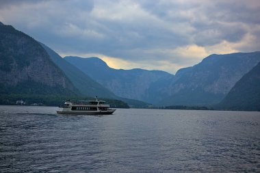 Sisli bulutlu bir günde Avusturya 'nın Salzkammergut kasabası yakınlarındaki Hallstatt Gölü Hallstatter' inde turistlerle dolu bir gemi. Avusturya 'nın en popüler turizm merkezlerinden biri..