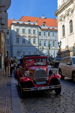 Prag, Çek Cumhuriyeti - 6 Ekim 2023: Prag 'ın merkezinde turistler için geleneksel güzel bir retro otomobil. Eski şehrin sokakları ve mimarisi.