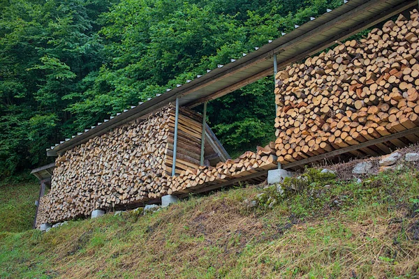 Hallstatt, Avusturya. Kışın ısınmak için odun yığını ile odun yığını. Çatının altına yığılmış odun yığını. Evi ısıtmak için hazırlanmış. Kışın ısıtmak için odun depolanır.