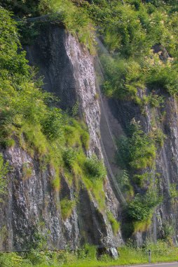 Kablo örgüsü Alplerdeki dik bir dağ yamacına sabitlenmiş. Yol boyunca aktif, güvenilir kaya düşüşü koruma sistemi. Taşların yola düşmesini engelliyor..