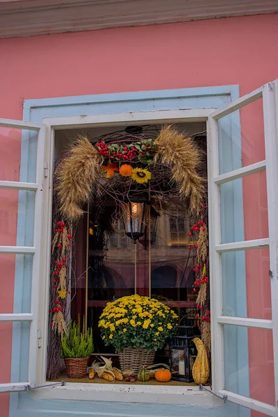 Delightful flower arrangement in front of the windows in the historical center of Prague, Czech Republic. National architecture. Beautiful vintage window with flowers and other items.