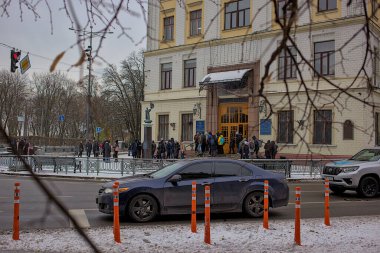 Kyiv Ukrayna - 23 Kasım 2023: Bir grup insan Kyiv 'deki Ulusal Ulaştırma Üniversitesi' nin ana girişinde toplandı. Karla kaplı şehrin sakin ama canlı bir atmosferi var..