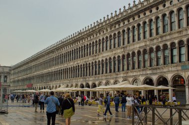 Venedik, İtalya - 15 Ekim 2024: Venedik 'teki ünlü atari salonu Rönesans' ın zamansız mimarisini sergiliyor. İnsanlar tarihi manzaranın tadını çıkarmak için San Marco Meydanı 'nda toplandılar..