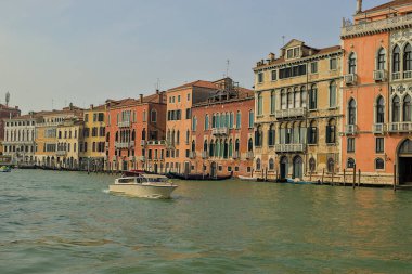 Venedik, İtalya - 15 Ekim 2024: Büyük Kanal, Venedik ana su yolu, şehir boyunca esiyor. Barbaro Sarayı ve çevresindeki binaların muhteşem manzarası. Bir tekne su yolu boyunca süzülür..