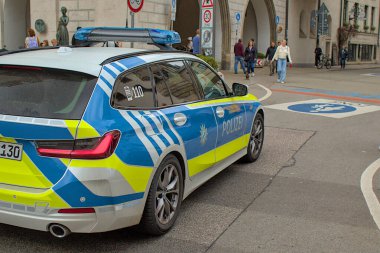 Münih, Almanya - 22 Ekim 2024: Münih 'te Karlstor yakınlarında bir Alman polis arabası park halinde. Yayalar yakınlarda yürüyor. Tarihi şehir merkezi eski ve modern mimarinin bir karışımıdır..