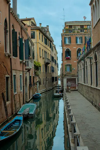 Eski binalar arasında dar kanallar var. Tekneler pencerelerin altında sessizce dinlenir. Su, sonsuz bir cazibe dünyasını yansıtır. İtalya, Venedik 'te geleneksel cadde.