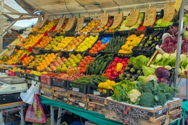 Padua, İtalya - 17 Ekim 2024: Renkli bir market taze meyve ve sebzelerle dolup taşıyor. Hava narenciye ve yeşillik kokusuyla dolu. İnsanlar en iyi ürünü seçmek için toplanır..