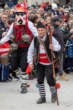 Shiroka Laka, Bulgaristan - 05 Mart 2023: Shiroka Laka Bulgaristan 'da maskeli balo festivali. Kukeri isimli maskeli insanlar dans ediyor ve kötü ruhları korkutmak için gösteri yapıyorlar.. 