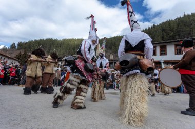 Shiroka Laka, Bulgaristan - 05 Mart 2023: Shiroka Laka Bulgaristan 'da maskeli balo festivali. Kukeri isimli maskeli insanlar dans ediyor ve kötü ruhları korkutmak için gösteri yapıyorlar.. 