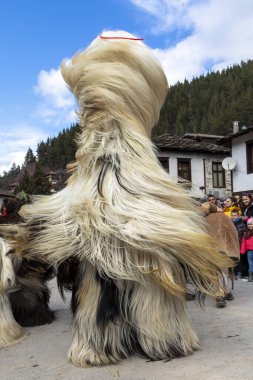 Shiroka Laka, Bulgaristan - 05 Mart 2023: Shiroka Laka Bulgaristan 'da maskeli balo festivali. Kukeri isimli maskeli insanlar dans ediyor ve kötü ruhları korkutmak için gösteri yapıyorlar.. 