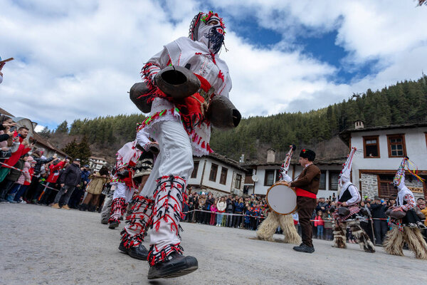 Shiroka Laka, Bulgaria - March 05, 2023: Masquerade festival in Shiroka Laka Bulgaria. People with a mask called Kukeri dance and perform to scare the evil spirits. 