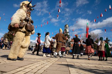 Elin Pelin, Bulgaristan - 11 Mart 2023: Elin Pelin Bulgaristan 'da maskeli balo festivali. Kukeri isimli maskeli insanlar dans ediyor ve kötü ruhları korkutmak için gösteri yapıyorlar.. 