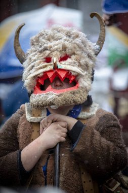 Breznik, Bulgaristan - 20 Ocak 2024: Bulgaristan 'ın Breznik kentinde maskeli balo festivali. Kukeri adındaki maskeli insanlar kötü ruhları korkutmak için dans edip gösteri yapıyorlar. Fotoğraf 20 Ocak 2024 'te çekildi.