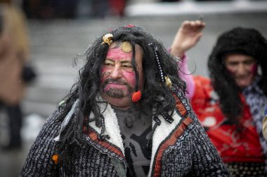 Breznik, Bulgaristan - 20 Ocak 2024: Bulgaristan 'ın Breznik kentinde maskeli balo festivali. Kukeri adındaki maskeli insanlar kötü ruhları korkutmak için dans edip gösteri yapıyorlar. Fotoğraf 20 Ocak 2024 'te çekildi.