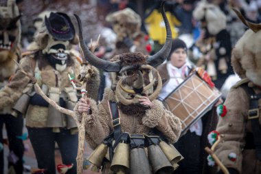 Breznik, Bulgaristan - 20 Ocak 2024: Bulgaristan 'ın Breznik kentinde maskeli balo festivali. Kukeri adındaki maskeli insanlar kötü ruhları korkutmak için dans edip gösteri yapıyorlar. Fotoğraf 20 Ocak 2024 'te çekildi.