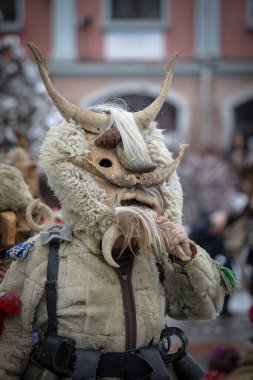 Breznik, Bulgaristan - 20 Ocak 2024: Bulgaristan 'ın Breznik kentinde maskeli balo festivali. Kukeri adındaki maskeli insanlar kötü ruhları korkutmak için dans edip gösteri yapıyorlar. Fotoğraf 20 Ocak 2024 'te çekildi.