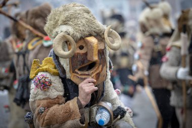 Breznik, Bulgaristan - 20 Ocak 2024: Bulgaristan 'ın Breznik kentinde maskeli balo festivali. Kukeri adındaki maskeli insanlar kötü ruhları korkutmak için dans edip gösteri yapıyorlar. Fotoğraf 20 Ocak 2024 'te çekildi.