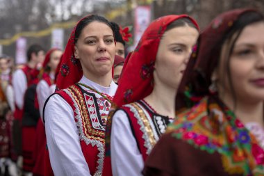 Pernik, Bulgaristan - 27 Ocak 2024: 30 Pernik Bulgaristan Maskeli Balo Festivali. Ulusal kostüm giymiş kadınlar dans ediyor ve doğurganlık ve sağlık ayini yapıyorlar..