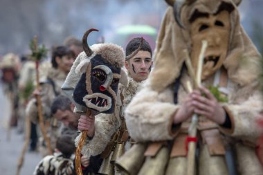 Bulgaristan 'ın Kyustendil kenti - 10 Şubat 2024: Bulgaristan' ın Kyustendil kentinde düzenlenen maskeli balo festivalinin birincisi. Geleneksel Kuker deri takım elbiseli adamlar pirinç çanlar eşliğinde dans ediyor ve doğurganlık ve sağlık ayini yapıyorlar..