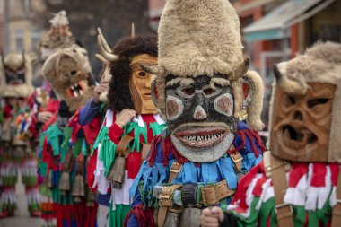 Bulgaristan 'ın Kyustendil kenti - 10 Şubat 2024: Bulgaristan' ın Kyustendil kentinde düzenlenen maskeli balo festivalinin birincisi. Geleneksel Kuker deri takım elbiseli adamlar pirinç çanlar eşliğinde dans ediyor ve doğurganlık ve sağlık ayini yapıyorlar..