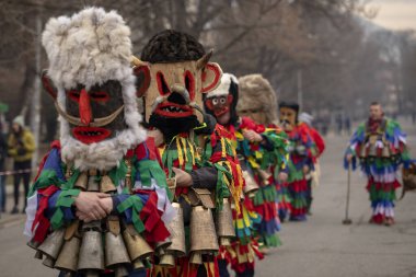 Bulgaristan 'ın Kyustendil kenti - 10 Şubat 2024: Bulgaristan' ın Kyustendil kentinde düzenlenen maskeli balo festivalinin birincisi. Geleneksel Kuker deri takım elbiseli adamlar pirinç çanlar eşliğinde dans ediyor ve doğurganlık ve sağlık ayini yapıyorlar..