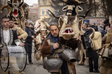 Bulgaristan 'ın Kyustendil kenti - 10 Şubat 2024: Bulgaristan' ın Kyustendil kentinde düzenlenen maskeli balo festivalinin birincisi. Geleneksel Kuker deri takım elbiseli adamlar pirinç çanlar eşliğinde dans ediyor ve doğurganlık ve sağlık ayini yapıyorlar..