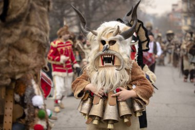Bulgaristan 'ın Kyustendil kenti - 10 Şubat 2024: Bulgaristan' ın Kyustendil kentinde düzenlenen maskeli balo festivalinin birincisi. Geleneksel Kuker deri takım elbiseli adamlar pirinç çanlar eşliğinde dans ediyor ve doğurganlık ve sağlık ayini yapıyorlar..