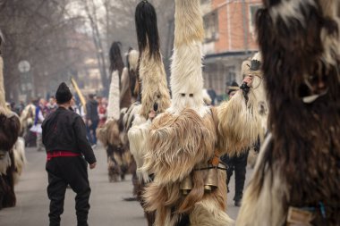 Bulgaristan 'ın Kyustendil kenti - 10 Şubat 2024: Bulgaristan' ın Kyustendil kentinde düzenlenen maskeli balo festivalinin birincisi. Bulgar halk kostüm giymiş kadınlar bakır çanlar eşliğinde dans ediyor ve doğurganlık ve sağlık ayini yapıyorlar.